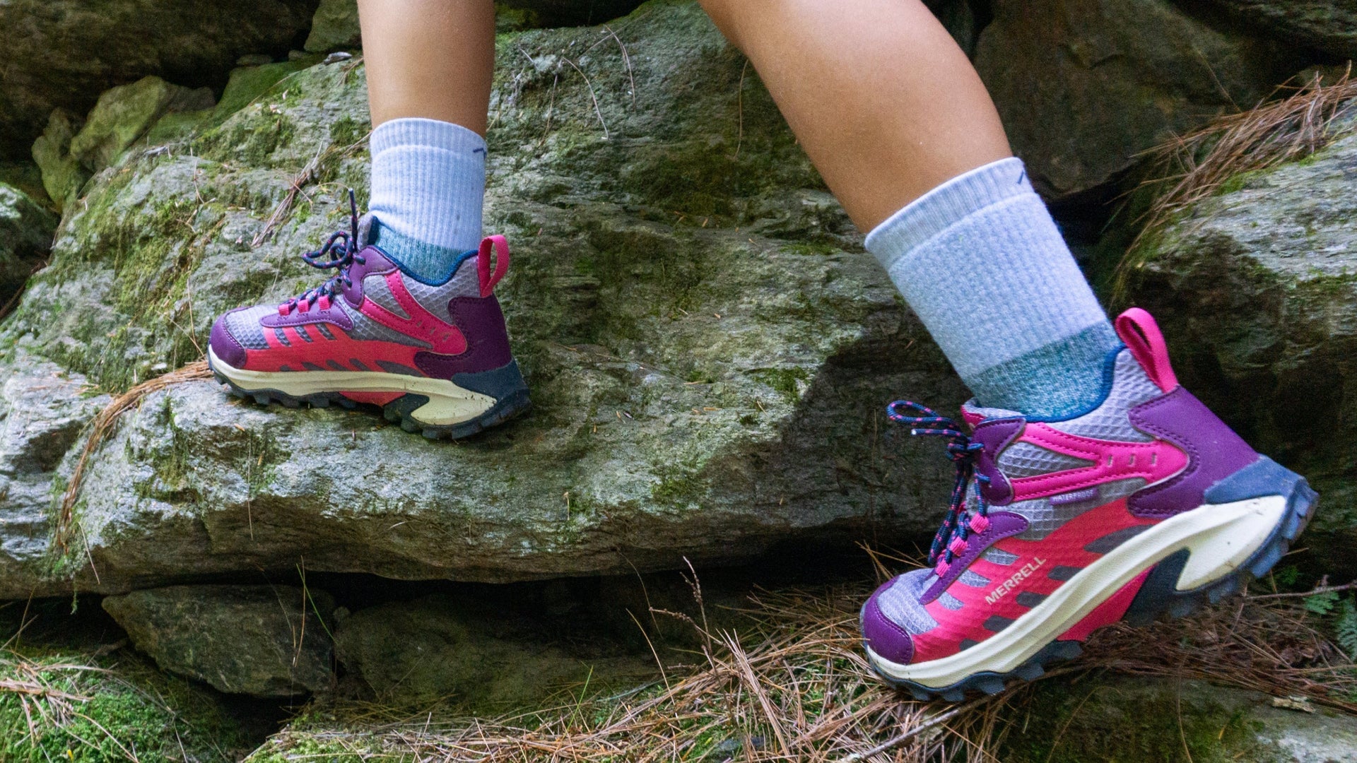 model in hiking sneakers wearing the kids' hill topper micro crew