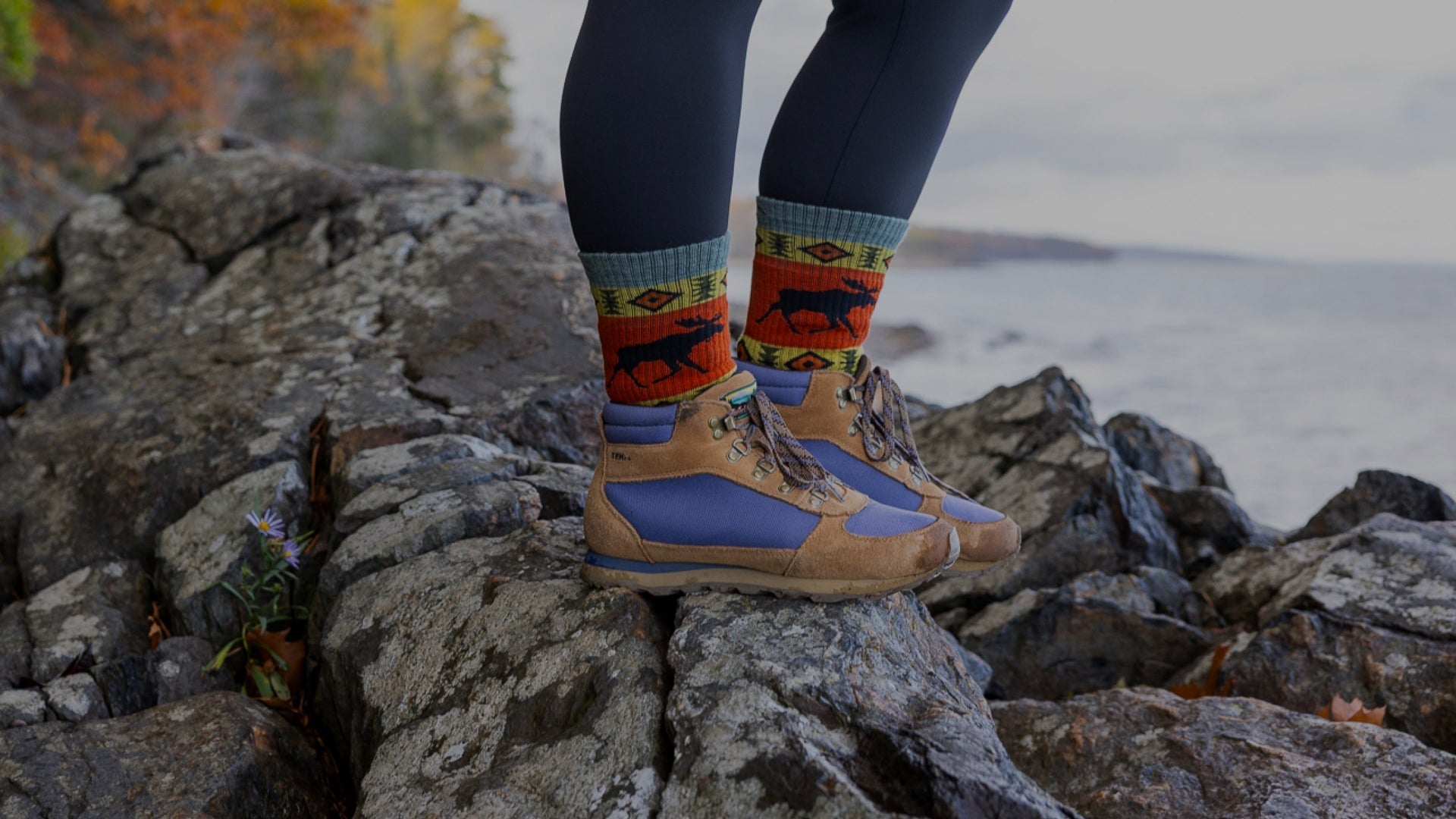 Models feet standing on rock edge near water wearing the vanna grizzle