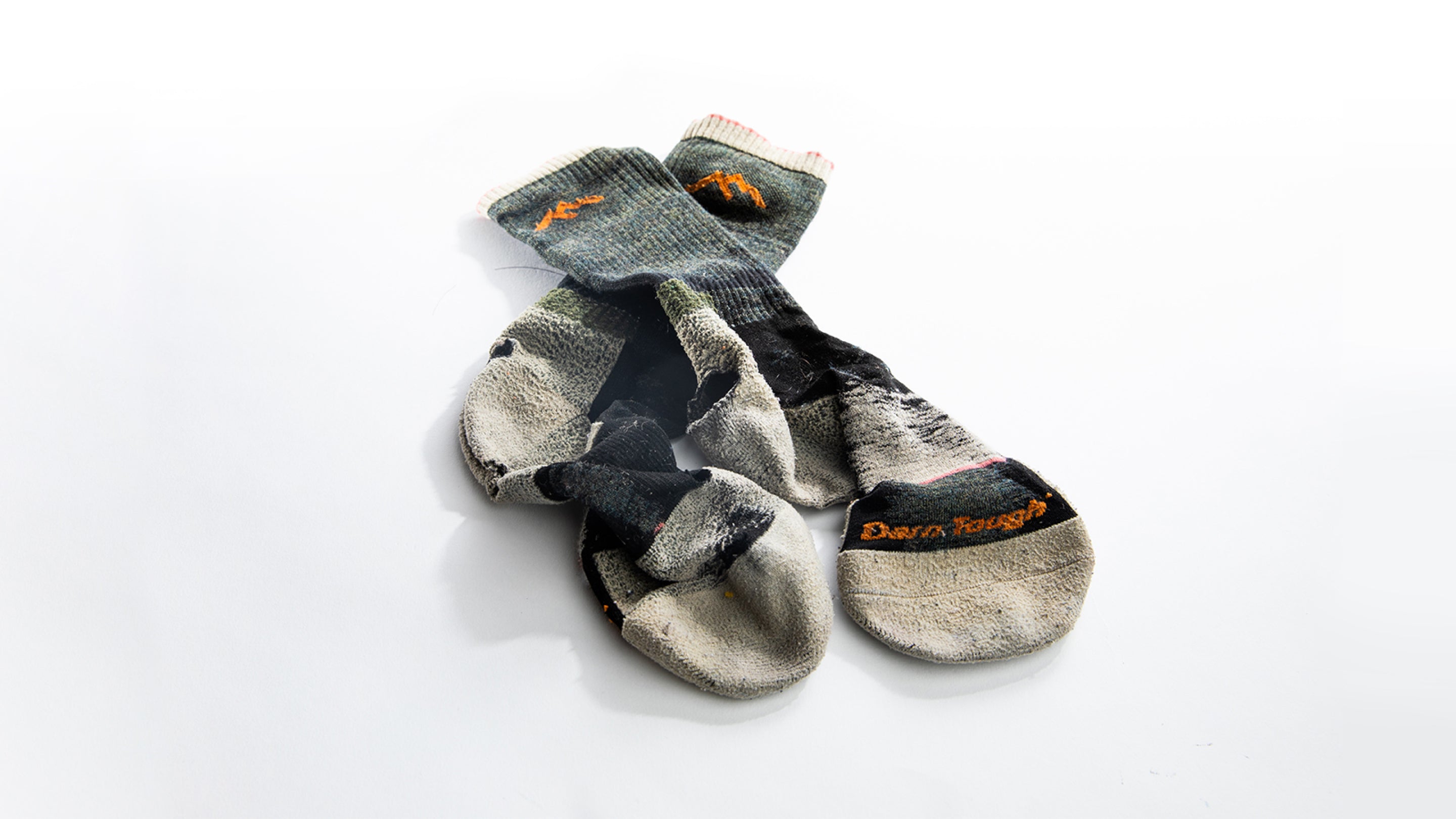 A pair of Darn Tough socks with holes ready to be sent to our warranty team